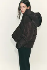 Anorak acolchado de corte corto, resistente al agua y al viento. Cuenta con cuello subido, capucha ajustable con cordones, cierre frontal con cremallera y bolsillos laterales con forro polar. El bajo es ajustable mediante cordones elásticos.