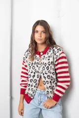 Saco de punto con diseño combinado, presenta un estampado animal print en el cuerpo y mangas con rayas horizontales en rojo y beige. Posee cuello redondo, cierre frontal con botones y terminaciones en tejido acanalado rojo.