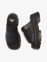 Sandalia negra de cuero con plataforma Mattison, suela híbrida de EVA y PVC con dibujo dentado, ranurado característico de Dr. Martens y costura amarilla. Cuenta con plantilla de espuma cubierta en gamuza y correa ajustable con hebilla.