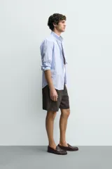 Bermuda regular fit azul marino confeccionada en lino, con bolsillos frontales, bolsillos traseros de doble vivo con botón y cierre frontal con cremallera y botón.