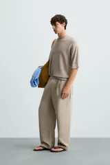 Camiseta color beige de punto tejido en hilatura de lino, con cuello redondo, manga corta y acabados en rib.