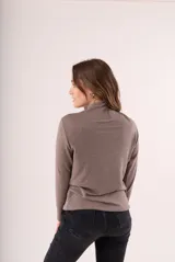 Polera de lanilla color champagne, de cuello alto y manga larga.