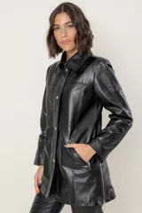 Campera de cuero en tono azul con efecto gastado, de corte recto y largo medio. Presenta cuello camisero, cierre frontal con botones a presión ocultos bajo una solapa y bolsillos laterales con cierre metálico.