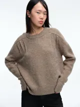 Sweater de tejido suave en tono beige melange, con cuello redondo, mangas largas y corte relajado.