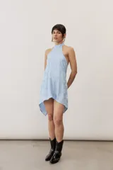 Top halter celeste con diseño asimétrico de corte más largo en la parte trasera, cuello alto y sutil estampado floral.