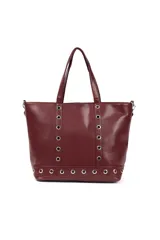 Cartera tipo tote de cuero sintético color bordó, con diseño decorado con ojales metálicos plateados en el frente y en la base. Cuenta con doble asa de hombro y cierre principal.