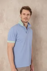 Remera azul marino de piqué de algodón, corte clásico, cuello polo con dos botones y logo de ave bordado en celeste en el pecho.