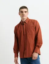 Camisa de franela lisa con cuello button-down, manga larga, botones al tono y bolsillo frontal en el pecho.