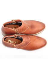 Botín negro de cuero con cierre metálico lateral, costuras decorativas y suela track con plataforma.