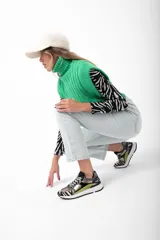 Zapatillas deportivas con estampado animal print, detalles en charol negro y apliques en verde lima.