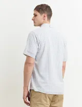 Camisa de manga corta a rayas verticales celestes y blancas, con cuello abotonado y corte clásico.