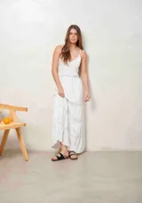 Vestido largo blanco de tirantes finos, con escote en V y detalles de inserciones de encaje broderie en la cintura y en la falda escalonada.