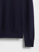 Buzo de punto con cuello alto tipo polera, de corte ajustado y manga larga.