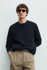 Sweater de punto color beige con textura tipo waffle, cuello redondo y mangas largas con acabado en rib.