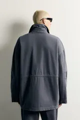 Parka relaxed fit de algodón color gris con efecto lavado. Cuenta con cuello solapa, cuatro bolsillos de plastrón con solapa en el frente y cierre frontal con cremallera oculta por solapa con botones a presión.