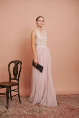 Vestido largo de tul plumetí en color rosa suave, con detalles de encaje bordado en el torso y volados en los hombros.