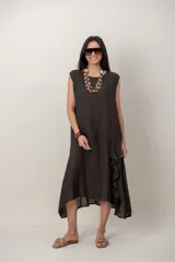 Vestido midi de lino color marrón, sin mangas, con corte irregular y detalle de volado vertical en el lateral.