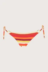 Calzón de bikini a rayas horizontales en tonos naranja, rojo, amarillo y beige. Tiene corte a la cadera, costados sin costuras, argollas doradas y tiras ajustables con detalles metálicos en las puntas.