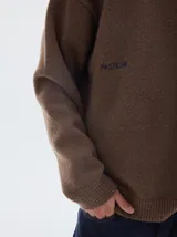 Buzo de punto color celeste, con cuello redondo y manga larga, de calce holgado y puños acanalados.