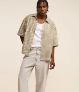 Pantalon de jean gris con lavado deslavado, de corte baggy y silueta holgada. Cuenta con bolsillos al frente y atras, y cierre de boton y cremallera.