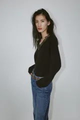 Jersey negro de manga larga con escote en V adornado con encaje negro.