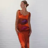 Vestido largo ajustado de microtul, color naranja con degradado a tonos rojizos y detalles en tonos morados/fucsia en la zona del torso. Presenta escote en V con efecto drapeado y tirantes anchos.