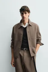 Sobrecamisa negra de corte boxy fit en tejido compacto, con cuello solapa, manga larga con puño abotonado, bolsillos frontales aplicados y cierre frontal de botonadura.