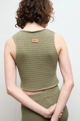 Chaleco negro de punto con escote en V y cierre frontal con dos ganchos metálicos.