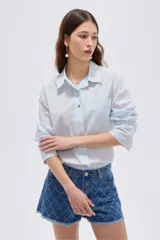 Camisa de algodón con estampado animal print en tonos marrones, de corte holgado, manga larga, cuello camisero y cierre frontal con botones.