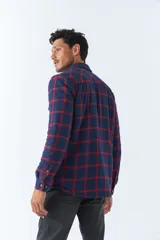 Sobrecamisa de algodón a cuadros color ladrillo, con interior de corderito, cierre con botones, bolsillos tipo cartera y logo en goma. El modelo usa talle M.