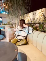 Sweater oversized color crema con rayas horizontales negras y mangas anchas con detalle de crochet.