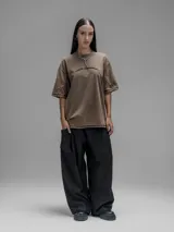 Remera de manga corta con diseño oversize, confeccionada en algodón con proceso batik artesanal en tono óxido. Presenta recortes superpuestos en el frente y costuras expuestas en mangas y cuerpo.