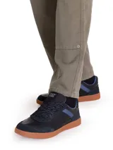 Sneakers de hombre Caterpillar modelo Pause Retro, color negro con detalles en azul y suela de goma color tostado. Confeccionados en cuero napa y gamuza, con cordones y suela texturizada con patrón de panal.
