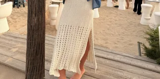 Falda larga de punto de crochet color beige, de tiro alto y diseño recto con tajos laterales.