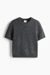 Buzo en punto fino suave, color gris oscuro, con cuello redondo y mangas cortas. Presenta remate acanalado en el cuello, los puños y el bajo.