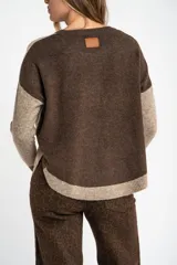 Sweater de punto con diseño color block en tonos beige, marrón y bordó, de cuello redondo y manga larga con puños acanalados en contraste.