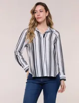 Camisa de crepe blanca con rayas verticales negras, cuello camisero, mangas largas raglán y cierre frontal con botones.