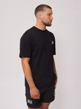 Remera blanca de hombre con logo de la marca Rusty estampado en el pecho y diseño a cuadros en la parte inferior trasera.