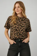 Remera de manga corta con cuello a la base y diseño holgado, confeccionada en algodón con elastano y estampado animal print.
