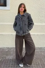 Cazadora de denim en tono gris lavado, con diseño de costuras marcadas, cuello camisero, cierre frontal con botones y bolsillos laterales.