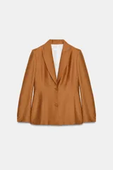 Blazer entallado color tostado confeccionado con lino. Cuenta con cuello solapa, manga larga con hombreras y cierre frontal con dos botones forrados a tono. Presenta forrería interior blanca.