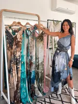 Vestido largo verde con diseño estampado tipo tie-dye y detalles dorados, de corte fluido, un solo hombro y diseño amplio.
