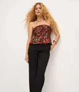 Pantalón carrot en crepé negro, de cintura alta, corte holgado en las caderas que se estrecha hacia los tobillos, con bolsillos laterales.