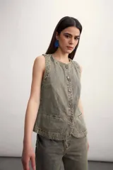 Chaleco azul de denim con cuello en V y cierre frontal con botones metálicos. Posee bolsillos delanteros y corte clásico.