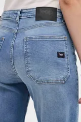 Jean de corte wide leg con tiro medio y cierre frontal con botones a la vista. Presenta un diseño holgado desde la cadera hasta el bajo con pierna ancha.