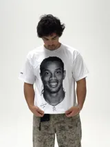 Remera blanca de corte boxy y diseño oversize, con estampa fotográfica frontal en blanco y negro del futbolista Ronaldinho.