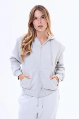 Buzo con capucha y cierre frontal completo, confeccionado en felpa suave, con bolsillos tipo canguro y cordones ajustables en la capucha.