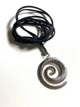 Collar con dije de acero quirúrgico en forma de espiral texturizada, suspendido de un lazo de cuero negro ajustable.