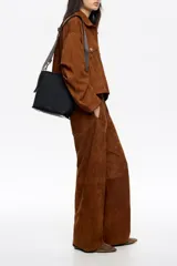 Bolso bandolera de tamaño pequeño en color verde oliva, confeccionado en poliamida con detalles en piel vacuna. Cuenta con asa larga regulable de tejido en color negro, cierre superior con cremallera y logo de la marca estampado en la parte frontal.