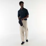 Pantalón de lino color beige con sutiles rayas verticales oscuras, de corte recto y holgado, con cintura elastizada y cordón ajustable.